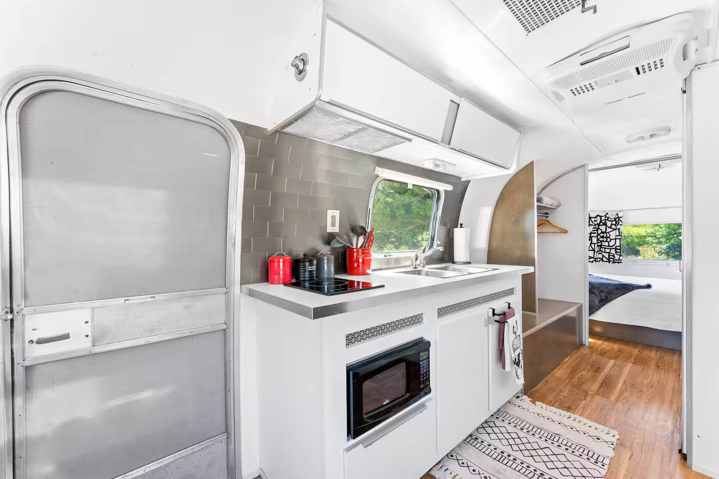 Kitchenette and bedroom inside The Joplin Airstream at Glamp Newport near Newport Rhode Island Kitchenette and bedroom interior inside The Joplin vintage Airstream rental at Glamp Newport in Portsmouth Rhode Island