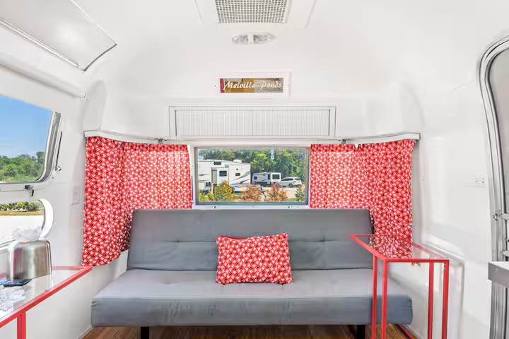 Cozy lounge seating inside The Joplin Airstream at Glamp Newport near Newport Rhode Island Interior lounge and seating area inside The Joplin vintage Airstream rental at Glamp Newport in Portsmouth Rhode Island