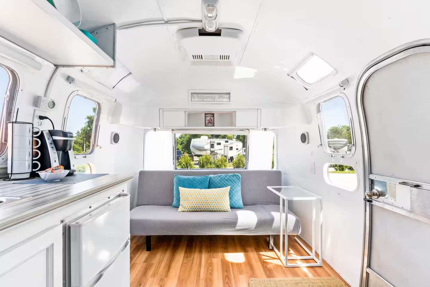 Cozy lounge seating inside The Ellington Airstream at Glamp Newport Interior seating and lounge area inside The Ellington vintage Airstream rental at Glamp Newport
