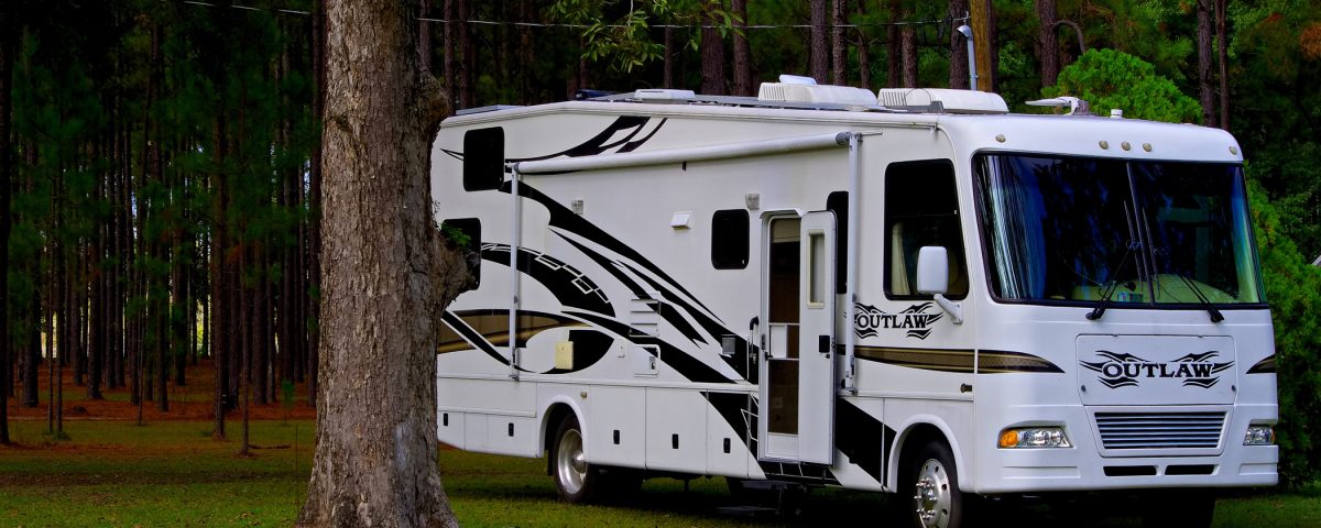 Luxury Class A motorhome parked at a wooded RV campsite