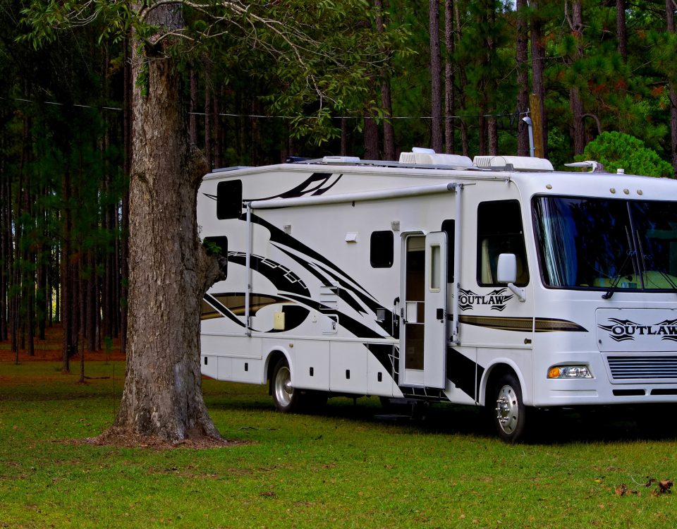 Luxury Class A motorhome parked at a wooded RV campsite