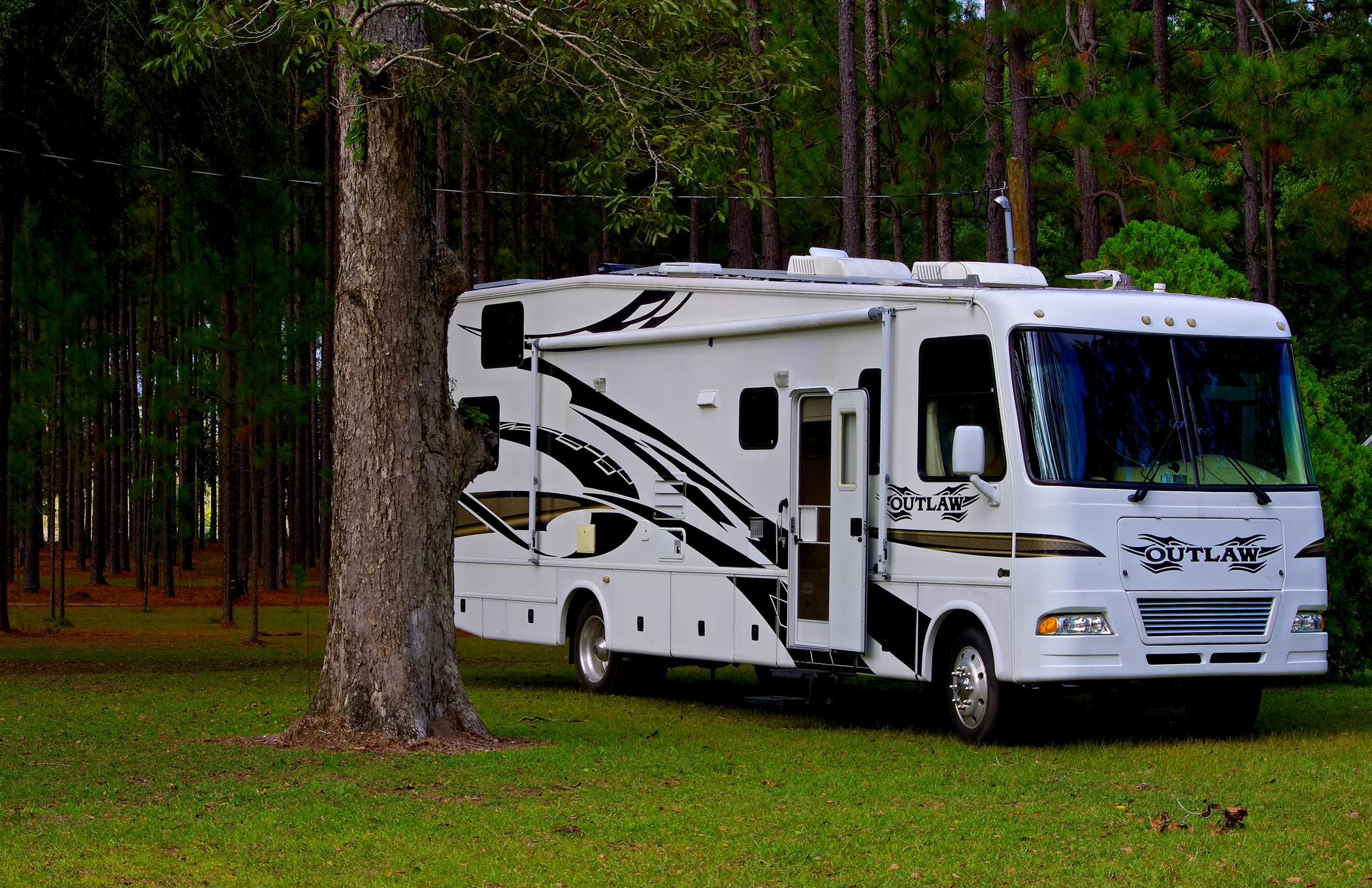 Luxury Class A motorhome parked at a wooded RV campsite